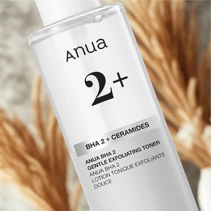 Clear glass bottle of anua bha 2 plus gentle exfoliating toner 150ml with white cap and black minimalist label containing salicylic acid