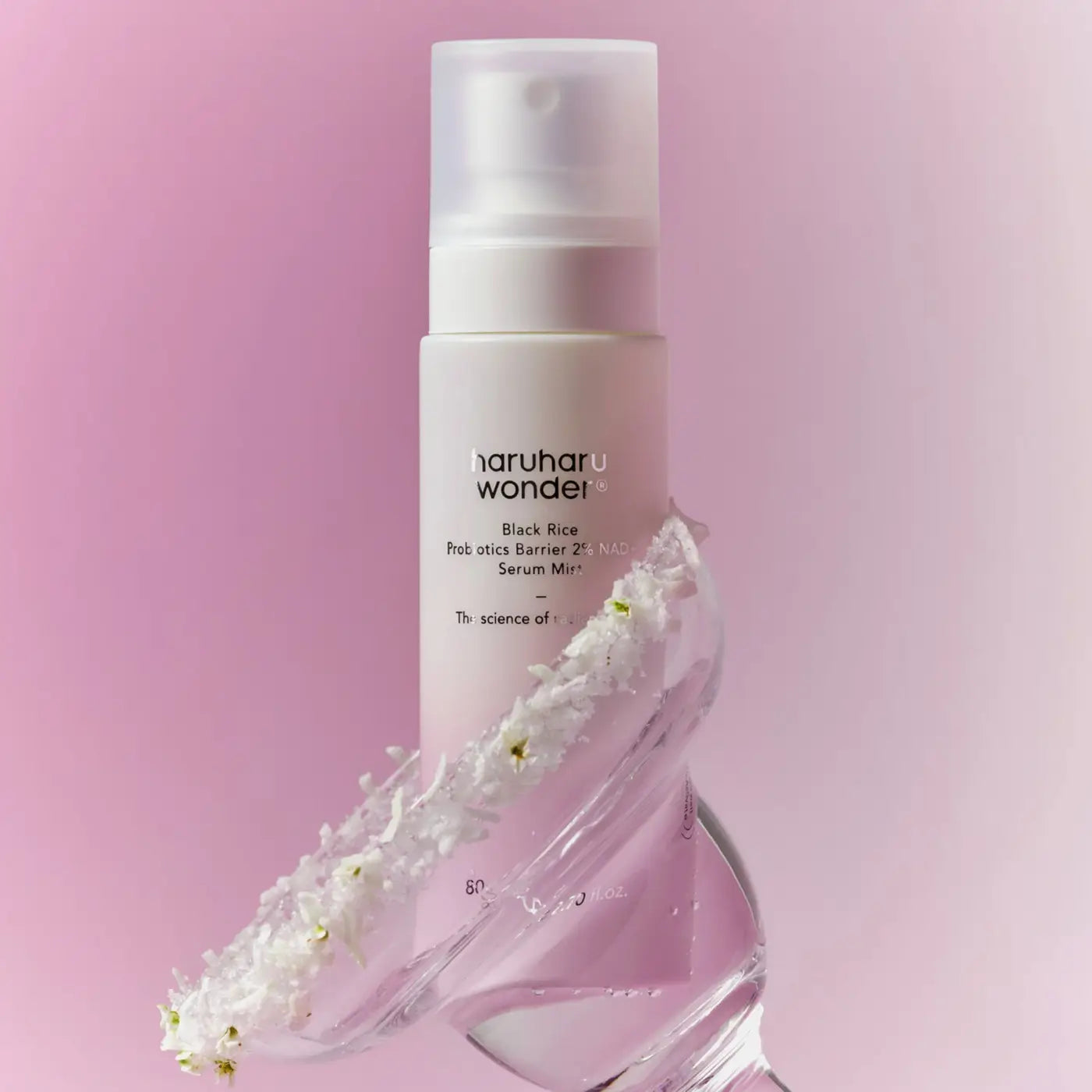 A sleek white spray bottle of haruharu wonder black rice probiotics barrier 2% nad serum mist with white flowers at base