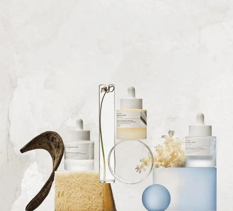 Three minimalist skincare serum bottles with white dropper caps and clear glass bodies, each containing a different colored liquid, light yellow, pale blue, and transparent, and labeled ’mud’ in black script.
