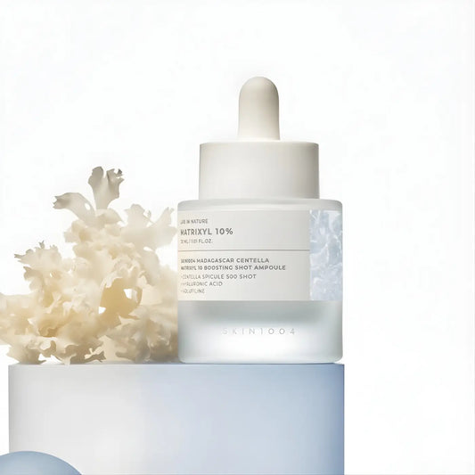 A sleek transparent glass bottle with white dropper cap containing madagascar centella matrixyl boosting shot ampoule
