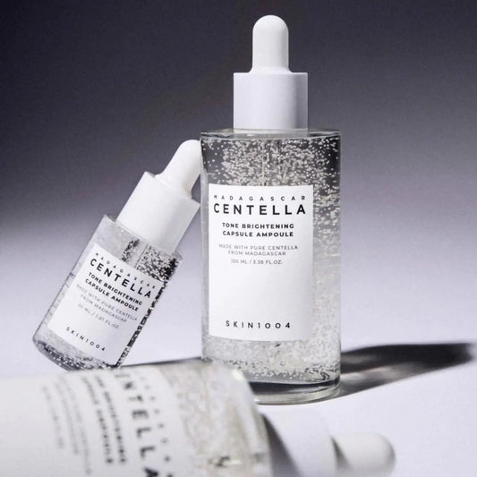 Clear glass bottle with white dropper cap containing sparkling transparent madagascar centella brightening capsule ampoule